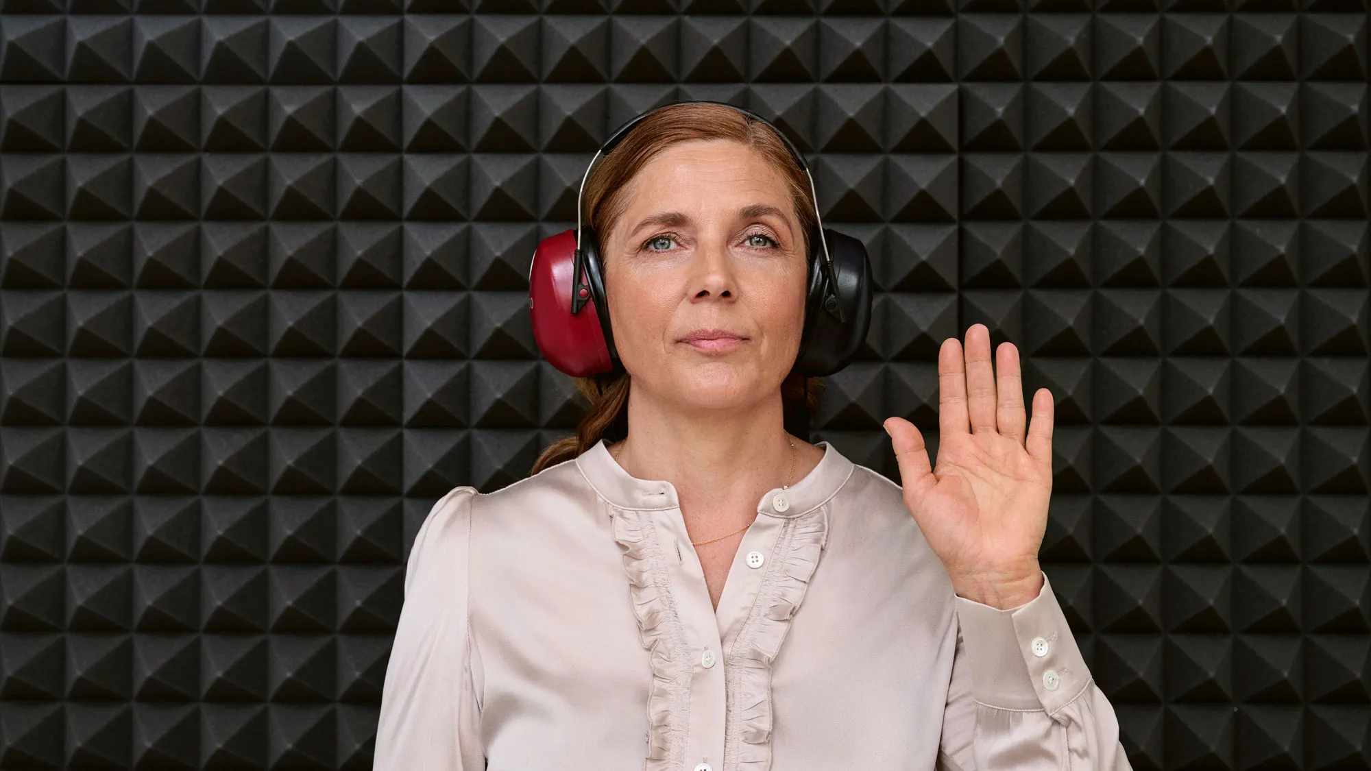 Cliente a realizar um teste auditivo dentro de uma cabine acústica durante uma consulta auditiva.