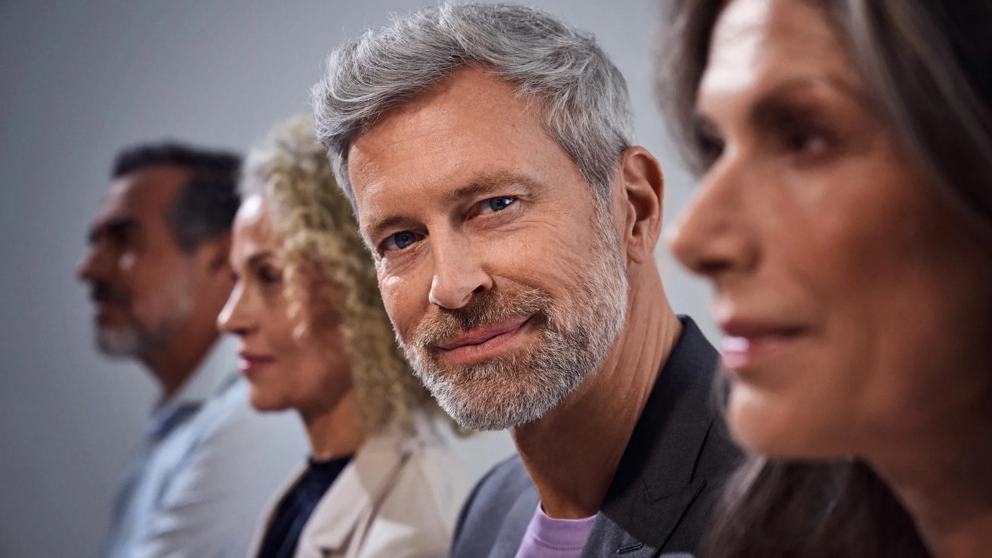 Multidão a aplaudir e homem a observar, com aparelhos auditivos.