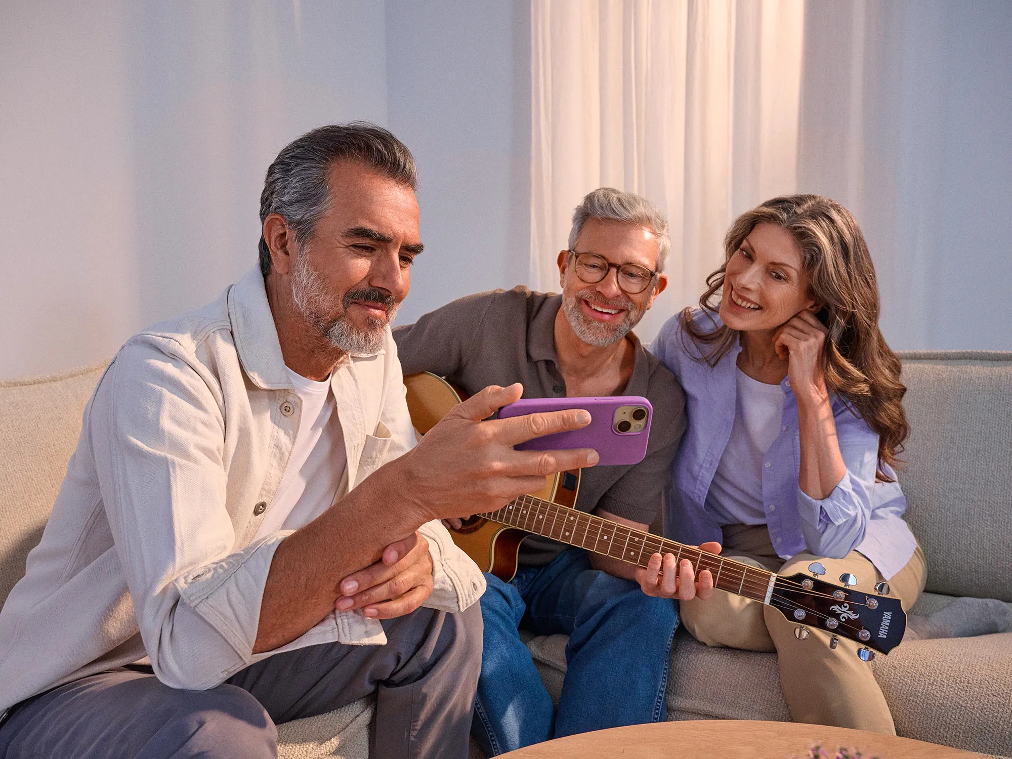 Amigos a ver algo num telemóvel, a celebrar a melhoria auditiva.