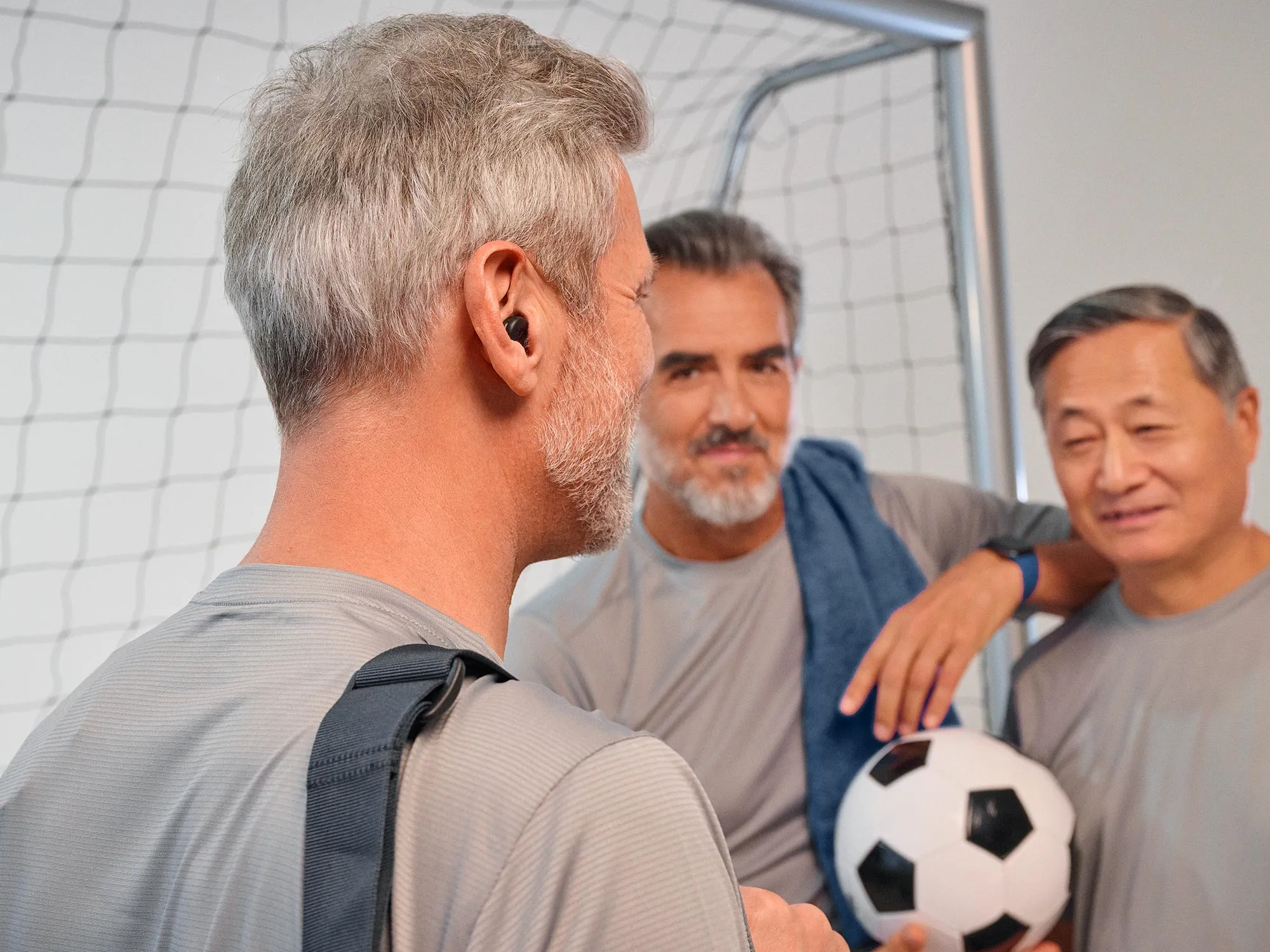 Man playing football wearing Signia Active hearing aids